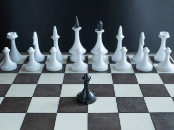 孤独的黑棋子独自站在对棋盘上的白色人物全军。概念描绘一个人军队著名的马丁路德金短语 - 我有一个梦想 — 图库照片