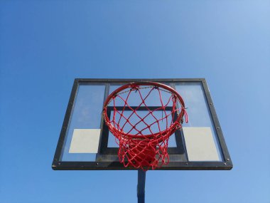 arka planda açık mavi gökyüzü ile alttan basketbol sepeti halka ön görüntü