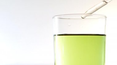scientiest kimyager yeşil sıvı ile şeffaf cam içine pipet kimyasal madde birkaç damlacıklar olun. 4k video görüntüleri