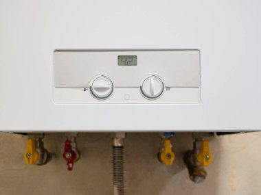 Gaz ateşiyle ısıtılan modern su ısıtıcısı kontrol paneli, sıcaklık göstergesi ve ayarlama tutamaklarıyla