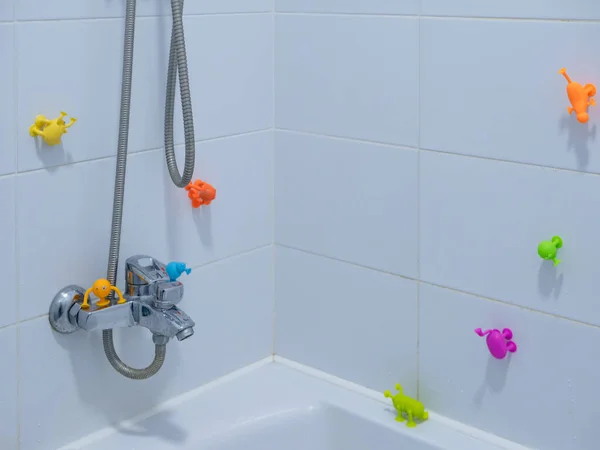Leeres Kinderbadezimmer Mit Weißen Fliesen Und Vielen Klebrigen Bunten Spielzeugen — Stockfoto