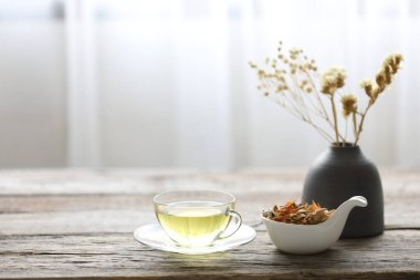 Bir kase limon otu ve kil kapta kurumuş çiçekli Pandanus yaprağı otu. 