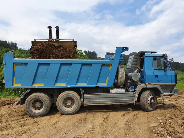 Kazıcı kamyonu kille dolduruyor.