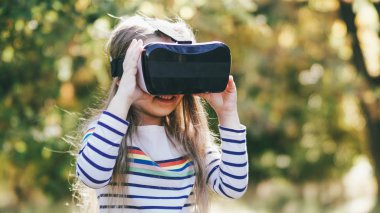 Anne, VR gözlüklerini izliyor. Kızlarla oynuyor. Küçük kız aile mutlu anları.