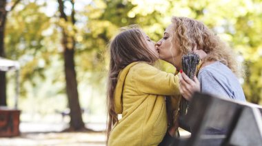 Anneler kızlarını öperken mutlu anlar anneler gününü sever kızlar.