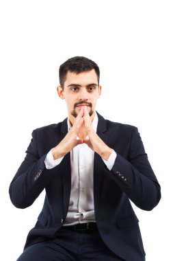 Bir iş adamı olarak katlanmış düşünceli eller oturur. Şık kıyafet, sakal, düşünme bak piercing.