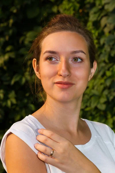 Yeşil yeşillik duvarının arka planına karşı genç kadın,