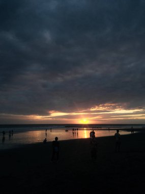 Bali, Endonezya - 09 Mayıs 2019: İnsanlar Seminyak plajında gün batımını bekliyorlar.