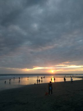 Bali, Endonezya - 09 Mayıs 2019: İnsanlar Seminyak plajında gün batımını bekliyorlar.