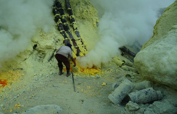 Ijen, Indonesia - October 13, 2019 : miners working to transport sulfur from the bottom of the Ijen crater