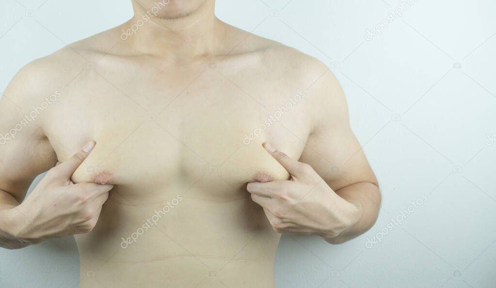 Close up man holding men boobs on white background. Diet, weight