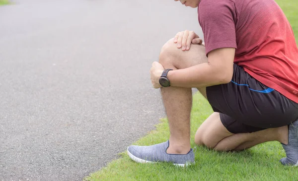 Zranění kolena. Mladý sportovec drží koleno s rukama v pa — Stock fotografie