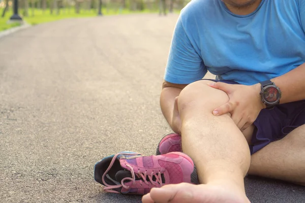 Knee Injuries. Fat man holding knee with his hands in pain after