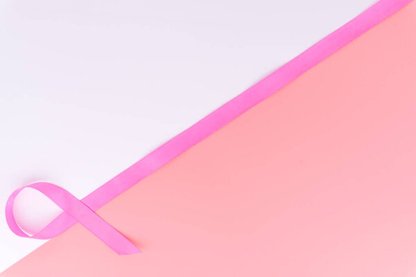 Pink ribbon breast cancer on pink and white background with copy