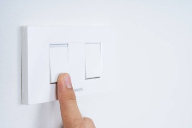 Evdeki beyaz duvarlı beyaz ışık düğmesini aç ya da kapat. Güç ve enerji tasarrufu. Metin için alanı kopyala.
