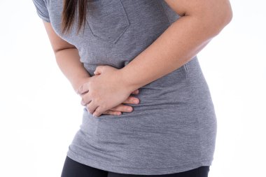 İzole edilmiş beyaz arka planda, midesi ağrıyan ve yaralanan bir kadın. Sağlık ve tıbbi konsept.