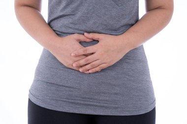 İzole edilmiş beyaz arka planda, midesi ağrıyan ve yaralanan bir kadın. Sağlık ve tıbbi konsept.