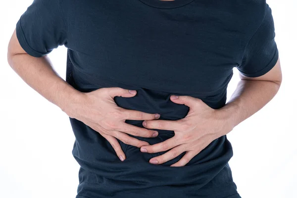 İzole edilmiş beyaz arka planda, midesi ağrıyan ve yaralanan bir adam. Sağlık ve tıbbi konsept.