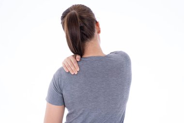 İzole edilmiş beyaz arka planda omuz ve boyun ağrısından ve yaralanmadan muzdarip bir kadın. Sağlık ve tıbbi konsept.