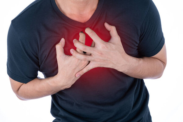 A man feeling exhausted and suffering from heart pain and injury on isolated white background with red spot. Health care and medical concept.