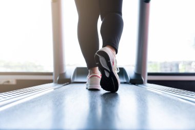 Spor salonundaki koşu bandında koşan kadın ayakkabılarını kapat. Diyet yaşam tarzı, kilo kaybı, mide kası, sağlıklı konsept.