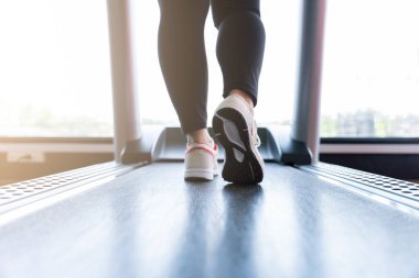 Spor salonundaki koşu bandında koşan kadın ayakkabılarını kapat. Diyet yaşam tarzı, kilo kaybı, mide kası, sağlıklı konsept.