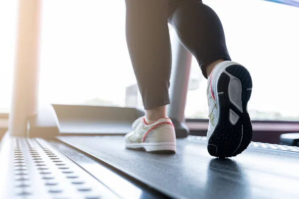Spor salonundaki koşu bandında koşan kadın ayakkabılarını kapat. Diyet yaşam tarzı, kilo kaybı, mide kası, sağlıklı konsept.