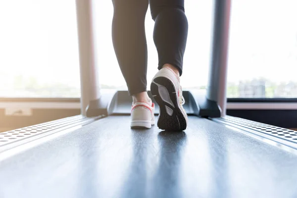 Spor salonundaki koşu bandında koşan kadın ayakkabılarını kapat. Diyet yaşam tarzı, kilo kaybı, mide kası, sağlıklı konsept.
