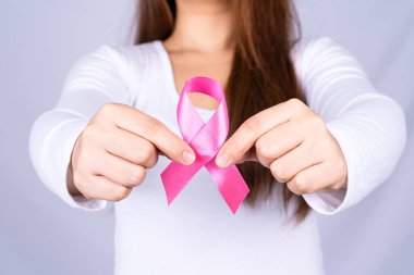 Kızıl AIDS farkındalık kurdelesi gri arka plandaki adamın elinde. Dünya Yardım Günü, Sağlık ve Tıbbi Konsept.