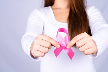 Kızıl AIDS farkındalık kurdelesi gri arka plandaki adamın elinde. Dünya Yardım Günü, Sağlık ve Tıbbi Konsept.