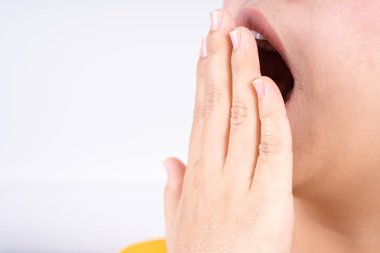 Asyalı kadın uyandıktan sonra ağzı açık bir şekilde esniyor. Sağlık hizmeti tıbbi veya günlük yaşam konsepti.
