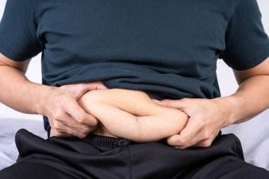 Şişman adamın şişkin göbeği, şişman göbeği var. Diyet yaşam tarzı, kilo kaybı, mide kası, sağlıklı konsept.