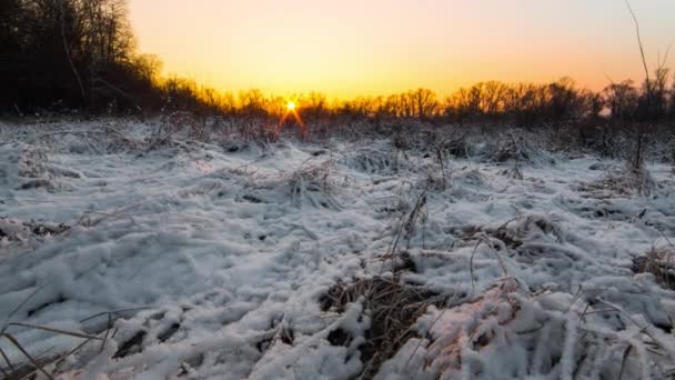 El tiempo apremia. Encantadora puesta de sol amarilla-naranja en un campo de nieve. — Vídeos de Stock