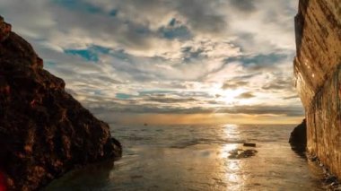 Zaman atlaması gece gündüz değişiyor. Tatil köyünün seti. Yaya yolları, yaya trafiği. Denizden rıhtıma. Deniz dalgaları kayalara çarpıyor. Sıcak bir yaz akşamı. Bulutlar gökyüzünde hareket eder. Kızlar ve araba