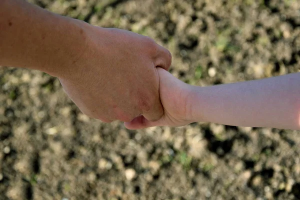 男性の手は子供の手を握っている 大人の男の手に子供の手 — ストック写真
