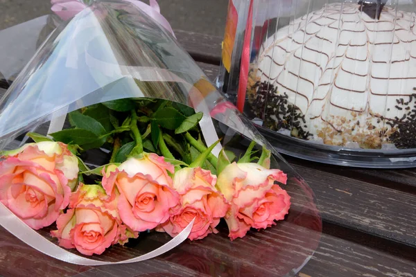 Bukiet Pięciu Różowych Róż Leży Drewnianej Ławce Obok Ciasta — Zdjęcie stockowe