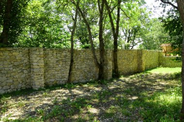 Bölgeyi sağlam bir kaldırım taşı duvar sarar. Bir kale, koruyucu bir duvar, sağlam bir temel..