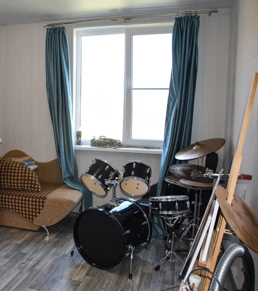 Drum set in the room by the window. Musician\'s room interior with drum kit. Modern drum kit in the room.
