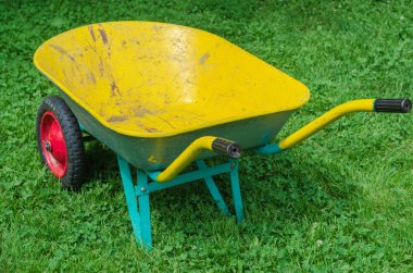 çim üzerinde duran tekerlekler ilerler ile sarı bahçe arabası