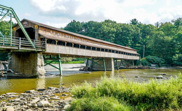 This is Harpersfield Covered Bridge that spans the Grand River in northeast Ohio the bridge is over a hundred years old and cars still cross it every day.