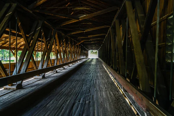 This is Harpersfield Covered Bridge that spans the Grand River in northeast Ohio the bridge is over a hundred years old and cars still cross it every day.