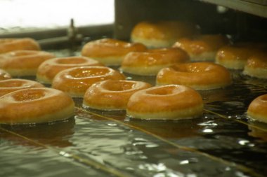 Raleigh, NC / United States - Oct. 12, 2019: Landcape interior image of the production of the iconic Krispy Kreme doughnut clipart