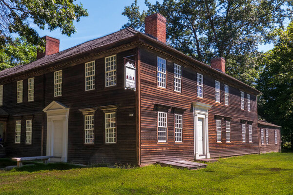 Дирфилд, штат Массачусетс - США - 23 августа 2025 г. Исторический деревянный барнард Таэб стоит под ясным небом с белыми окнами и яркой вывеской, вызывающей колоритное очарование Новой Англии..