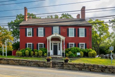 Monroe, NY - Sep 6, 2025: Tarihi kırmızı bina, McGarrah 's Stagecoach Inn, Köşe Taşı Masonik Tarihi Toplumu' nun evi, önemli bacaları, beyaz süslemeleri ve hoş geldin girişi olan.