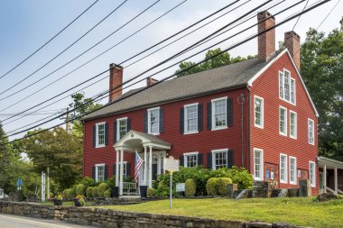 Monroe, NY - Sep 6, 2025: Tarihi kırmızı bina, McGarrah 's Stagecoach Inn, Köşe Taşı Masonik Tarihi Toplumu' nun evi, önemli bacaları, beyaz süslemeleri ve hoş geldin girişi olan.