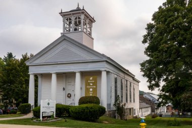 Monroe, New York - ABD - Sahne 6, 2025 Monroes huzur dolu köy parkında beyaz bir çardağı, ağaçları ve yansımaları olan Monroe Gölü
