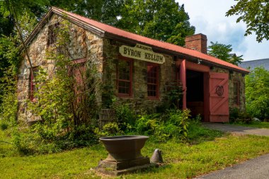 Monroe, NY - ABD - 6 Ekim 2025 Kırmızı bukleli tarihi taş demirci dükkânı ve Monroe, New York 'taki Müze Köyü' nde 