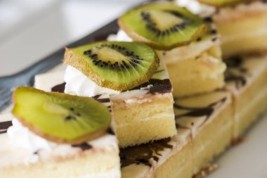 ake krem ve kivi beyaz bir plaka üzerinde bir dilim ile dekore edilmiştir. Seçici odak