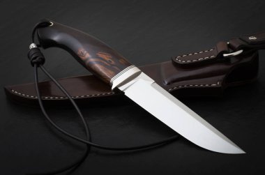 Siyah arka planda el yapımı avcı bıçağı. Deri Kaplama El Yapımı