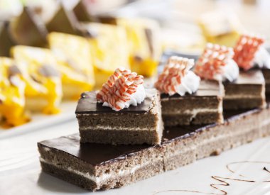 Bisküvi pasta, krem ve beyaz beyaz bir tabağa çikolata ile dekore edilmiştir. Seçici odak